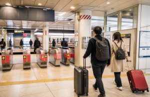 Travelers with luggage using station gates near Asakusa for airport access
